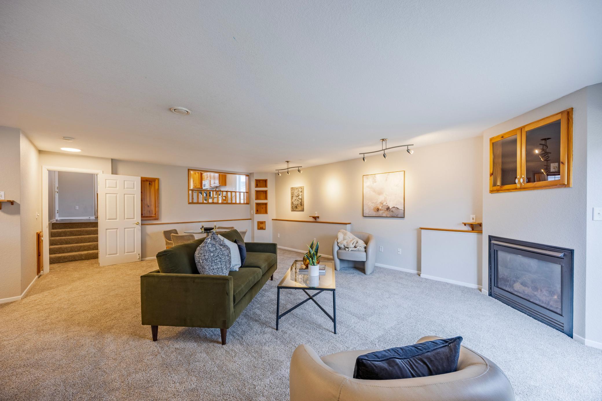 Gorgeous lower level living room from another angle showing steps to main level on back left.