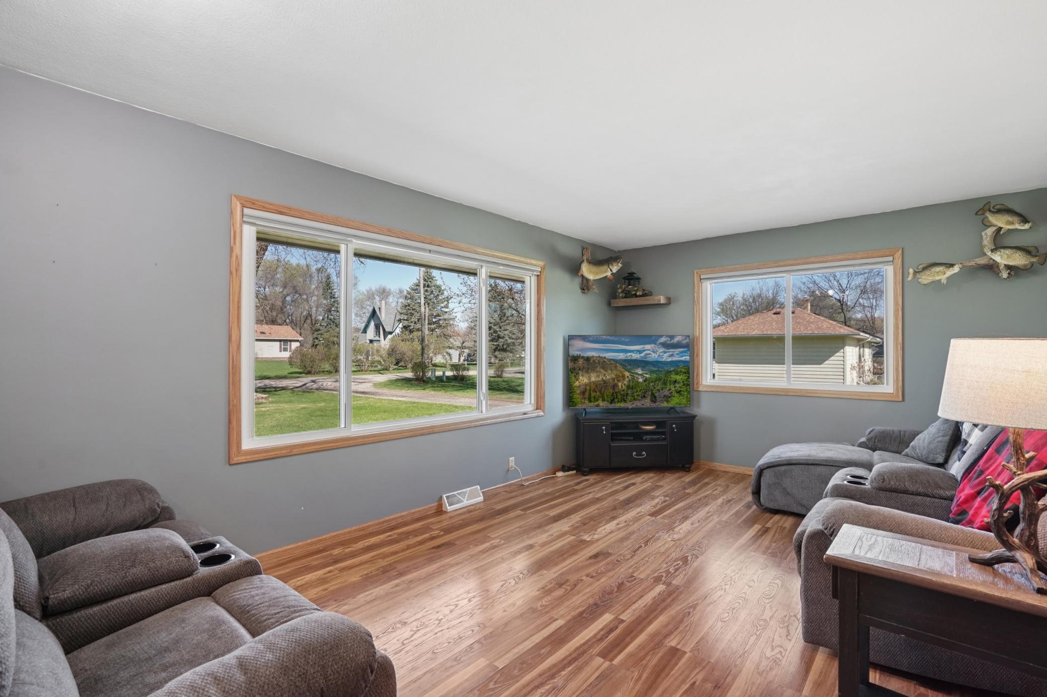 The living room features durable LVP flooring and large windows to let in tons of natural light!