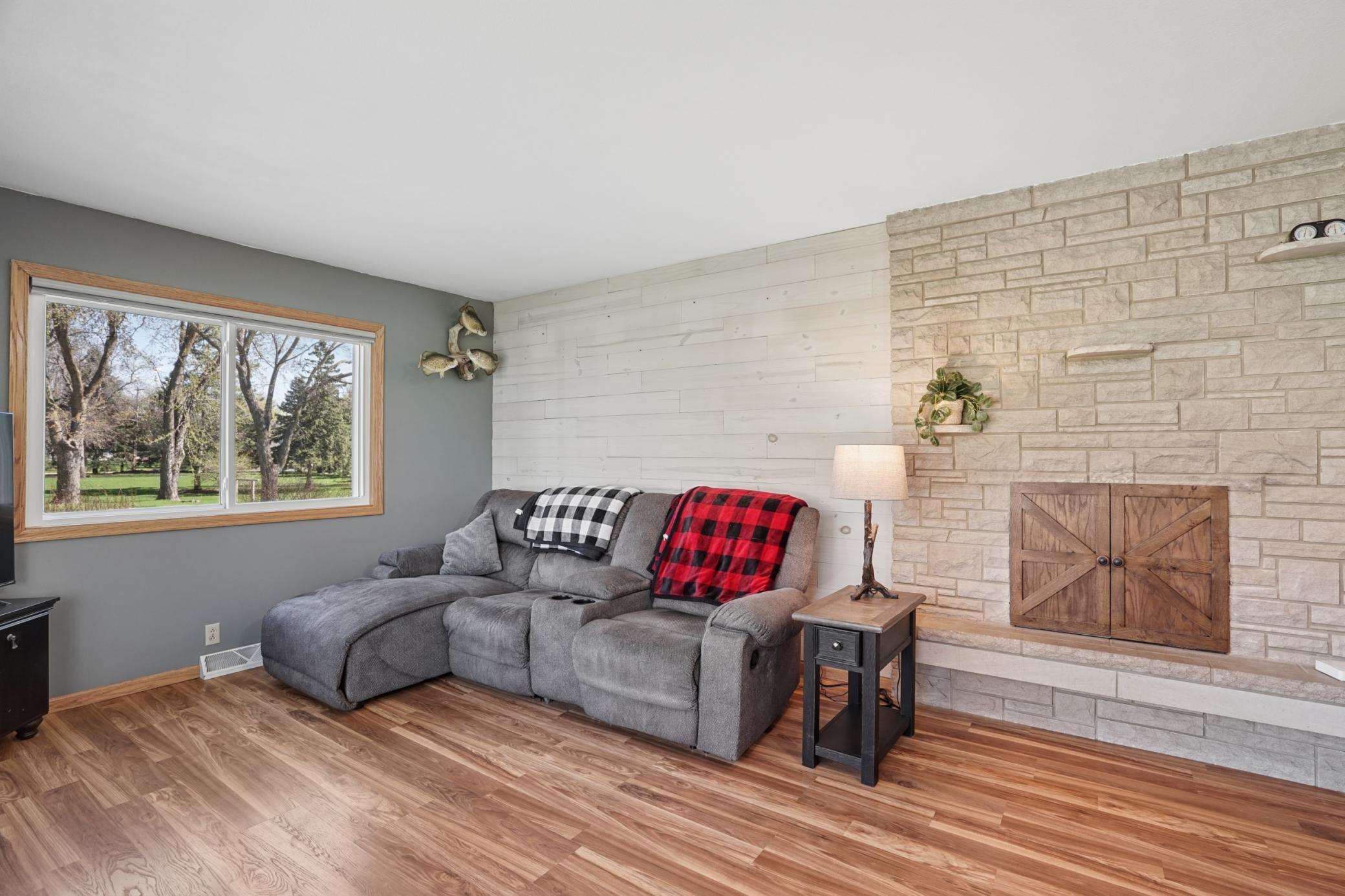The living room features a woodburning fireplace with a stone surround. Fireplace has not been used by the sellers.