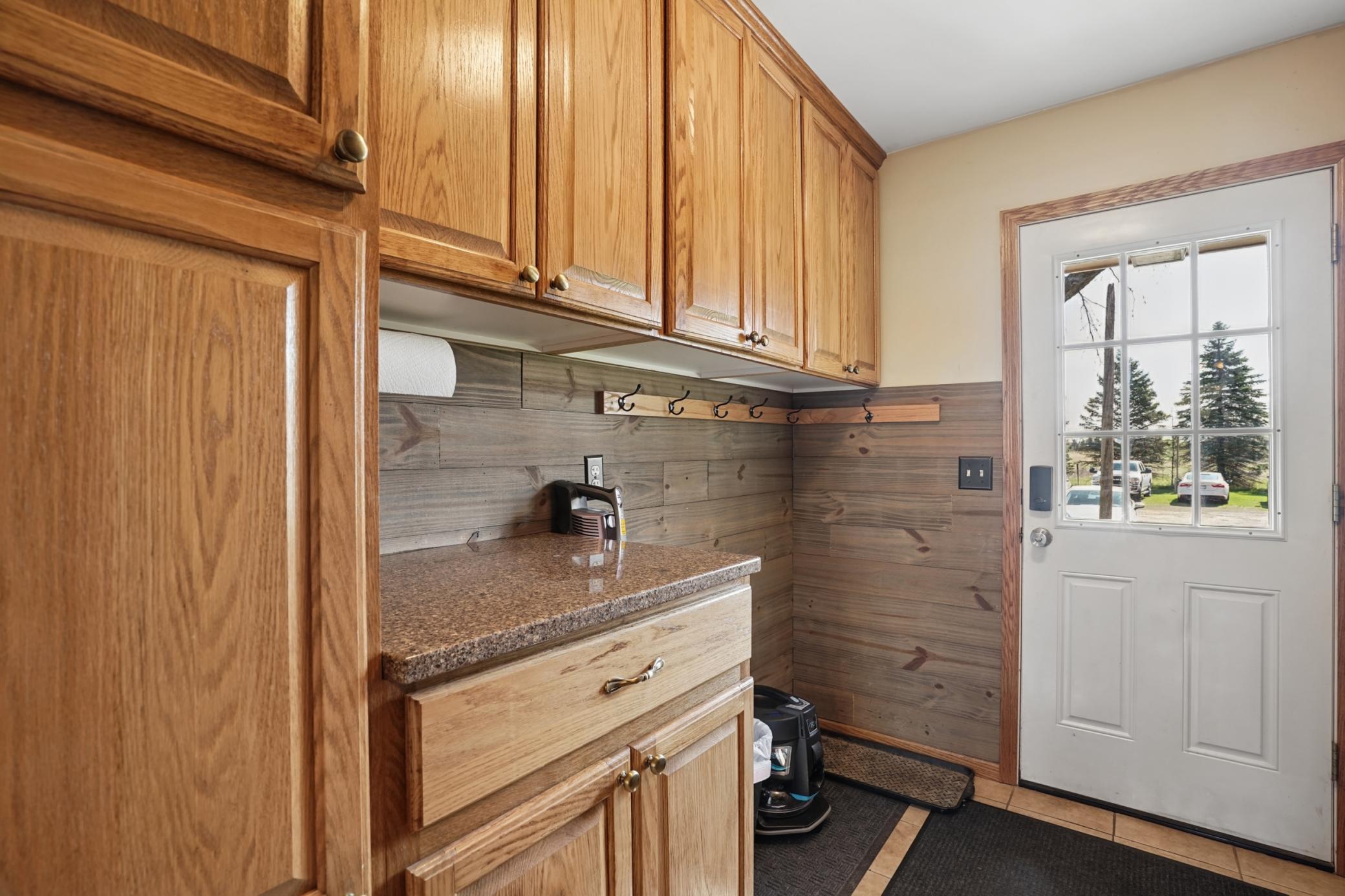 The mudroom features tons of cabinet space, tile floors, and hooks to hang items. Laundry hookups are available in the mudroom for the option of main floor laundry.