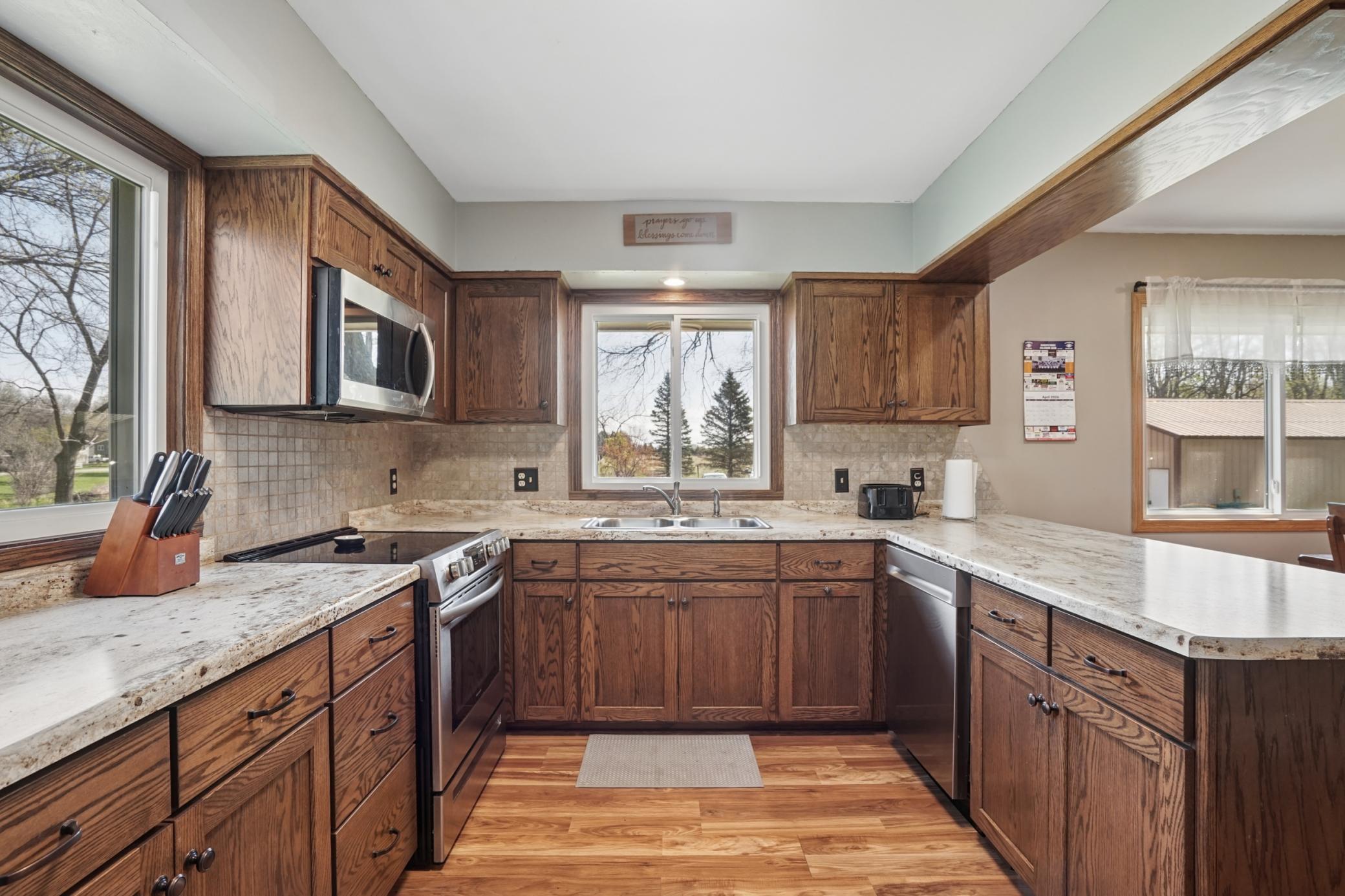 The kitchen features beautiful custom oak Schlangen cabinets. S.S. appliances include an electric range, dishwasher, microwave, and a refrigerator.