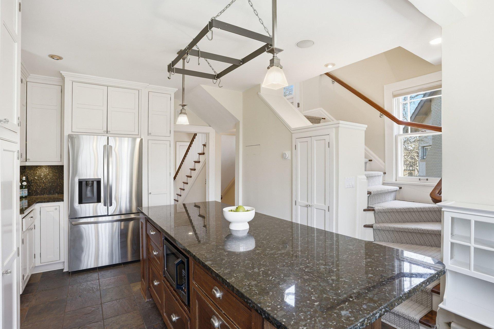 2200 Kenwood Parkway - Large center island with granite countertop and enameled cabinetry pullout storage. Note the 2nd staircase to the Upper Level