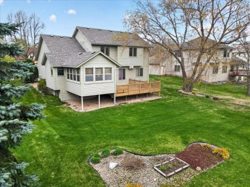 Another view of the backyard showing the large deck, 3-season porch and gardens.