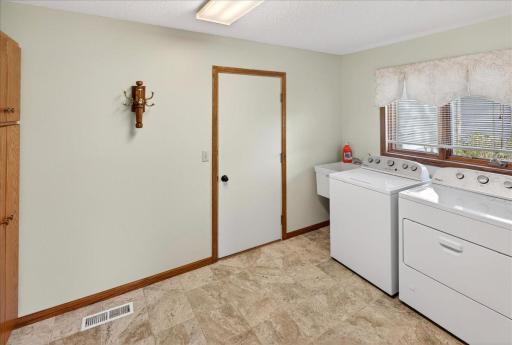 Convenient main level laundry room also functions as a mudroom that leads to the garage.