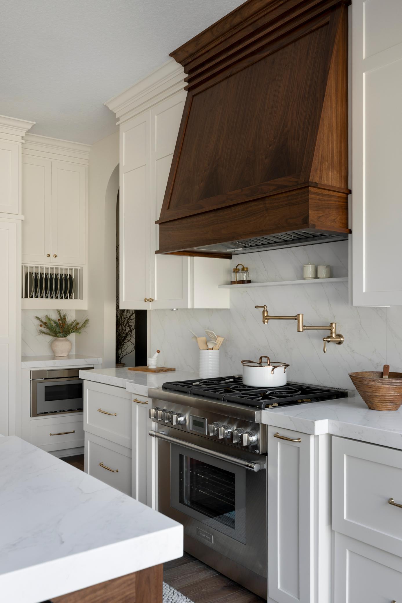 Kitchen featuring quartz back splash , pot filler & custom cabinetry