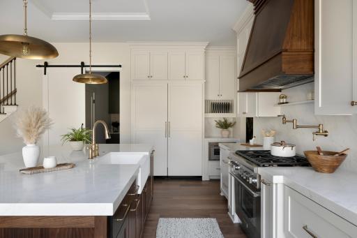 Kitchen featuring custom panel appliances and cabinetry