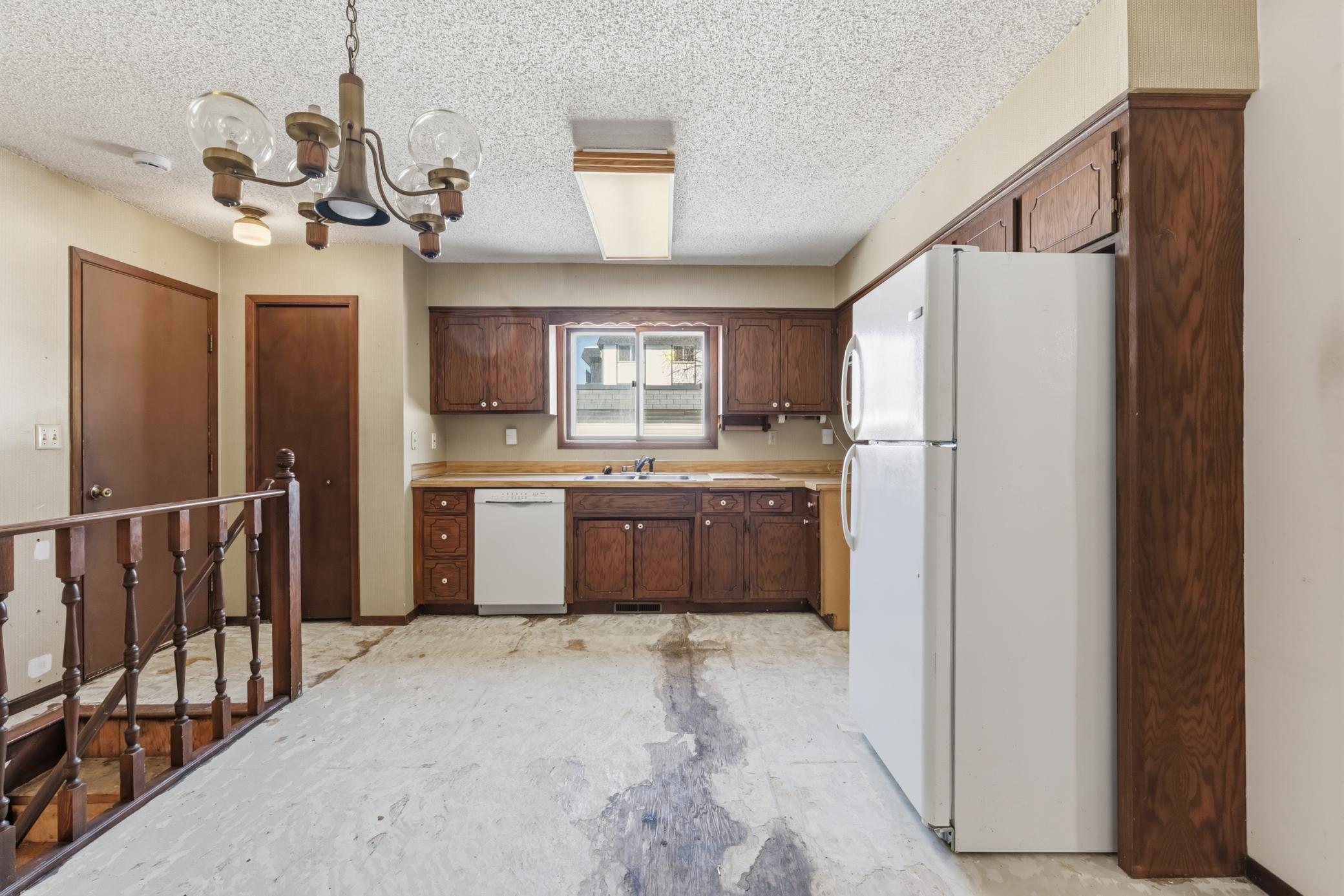 Roomy Kitchen and Dining Area, with Stairs to Lower Level just in from the Garage.