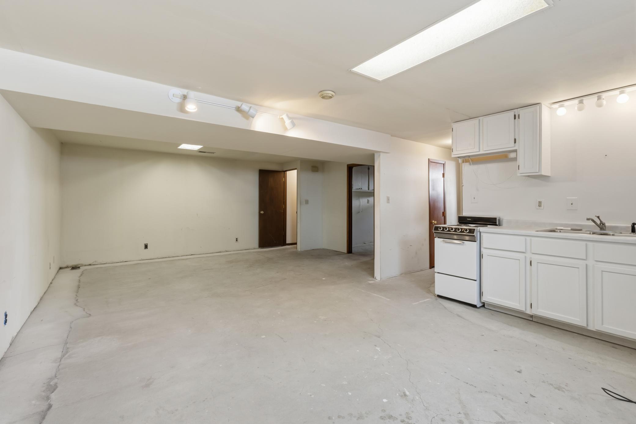 Lower Level Family Room with Stairs, Utility Room, 3rd Bedroom and 2nd Full Bath at Right.
