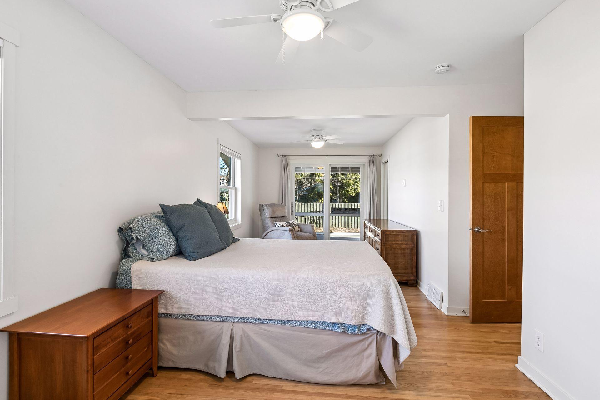 The primary bedroom is huge! Two bedrooms were made into one, and it is now the width of the home. The newer patio doors here lead out unto the porch.