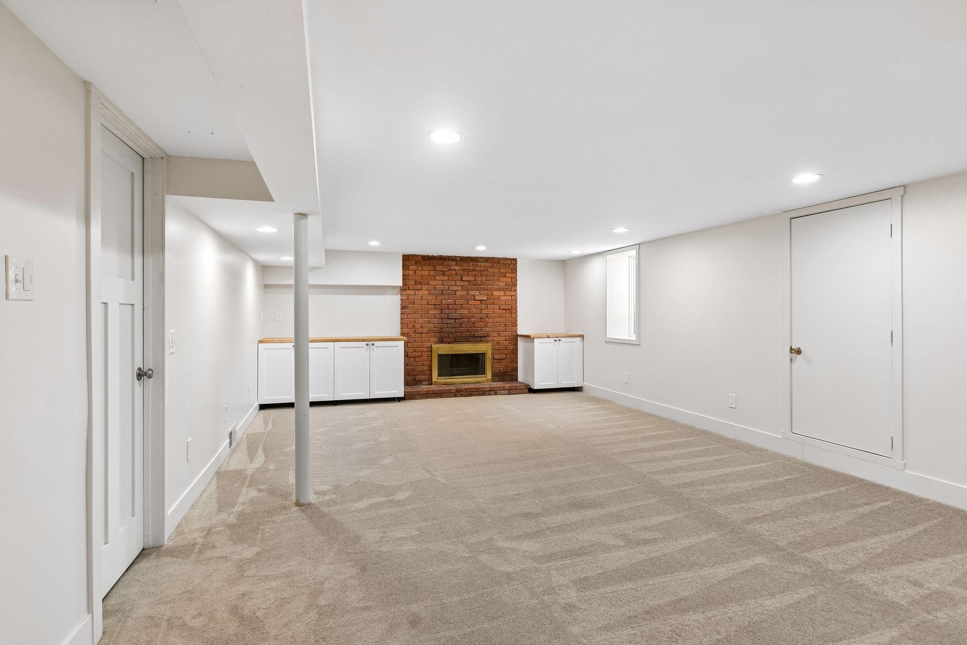 The wood fireplace here is flanked by built in cabinets.