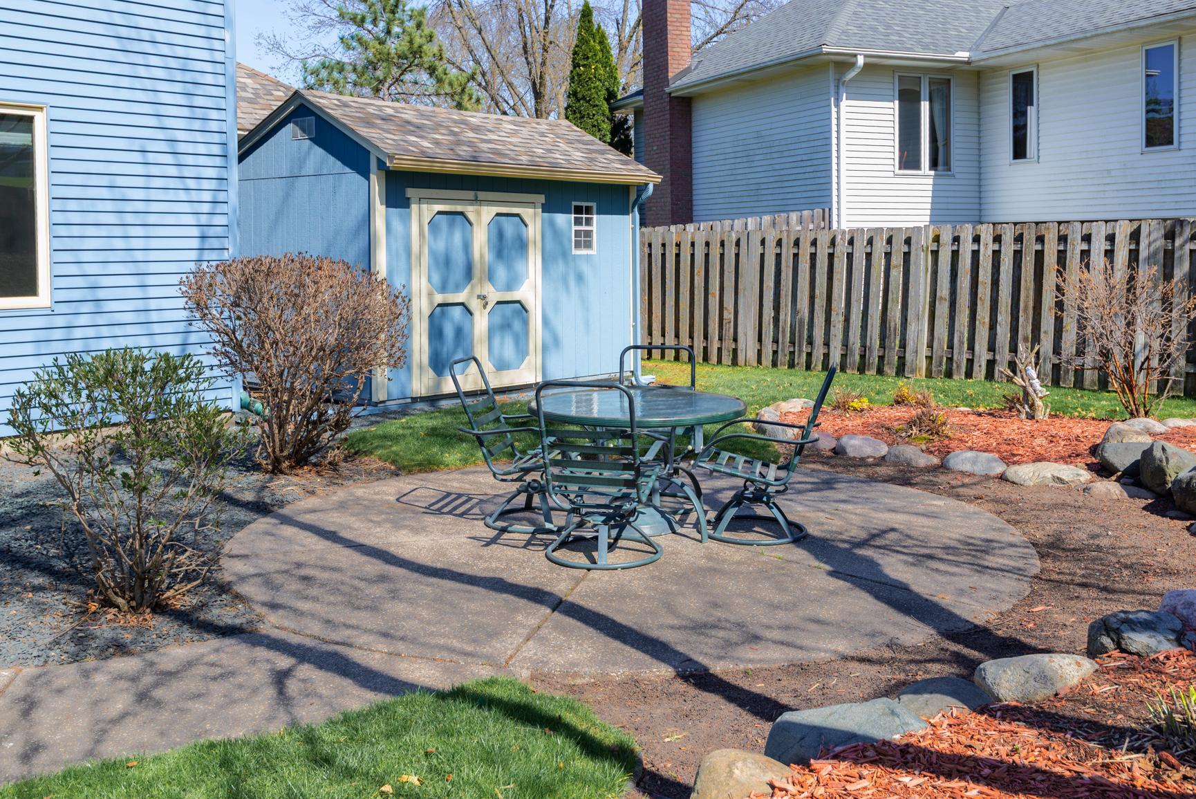Large round patio with landscaping ready to add your favorite flowering plants or vegetables.