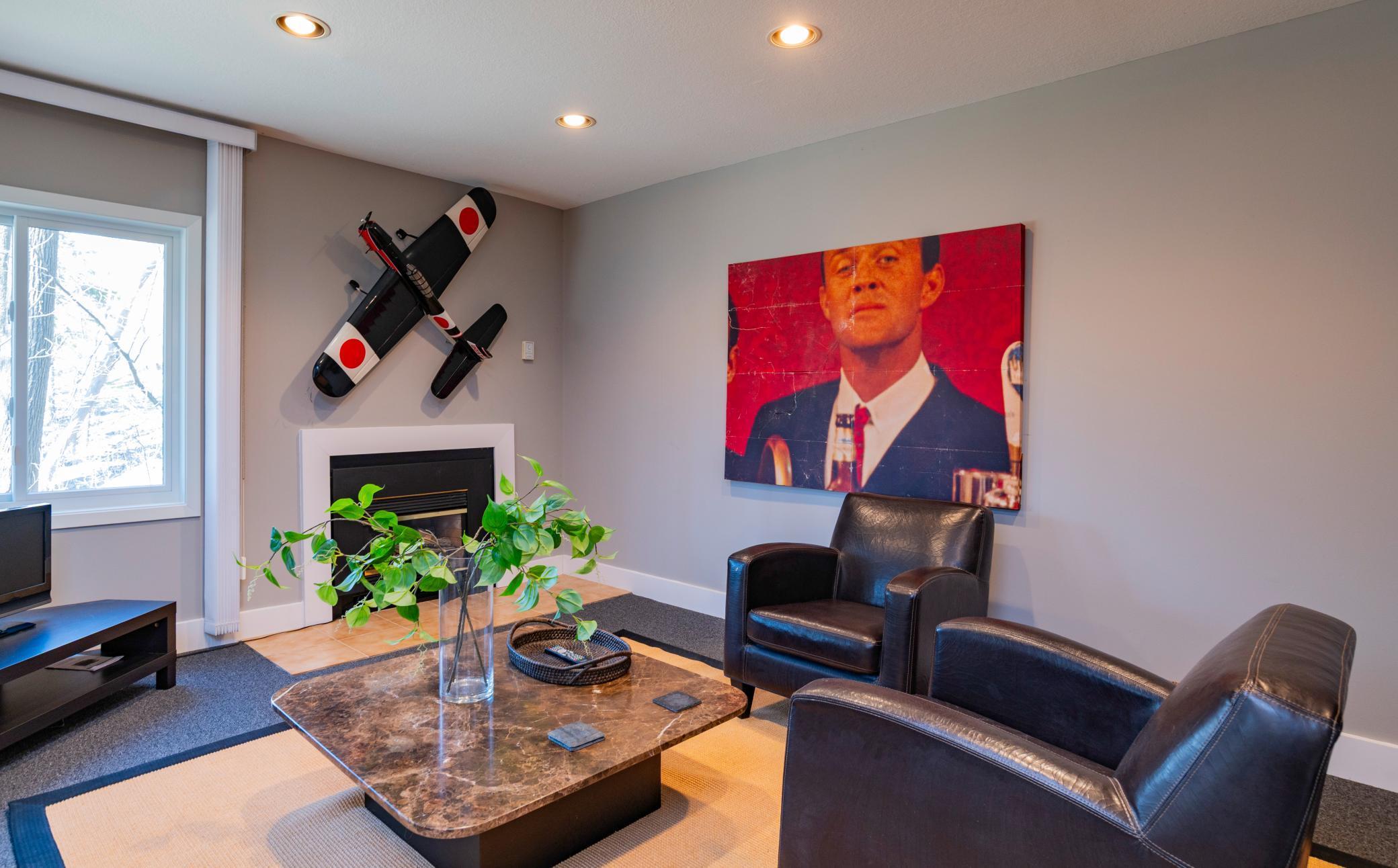 Lower level family room has corner windows and an electric fireplace