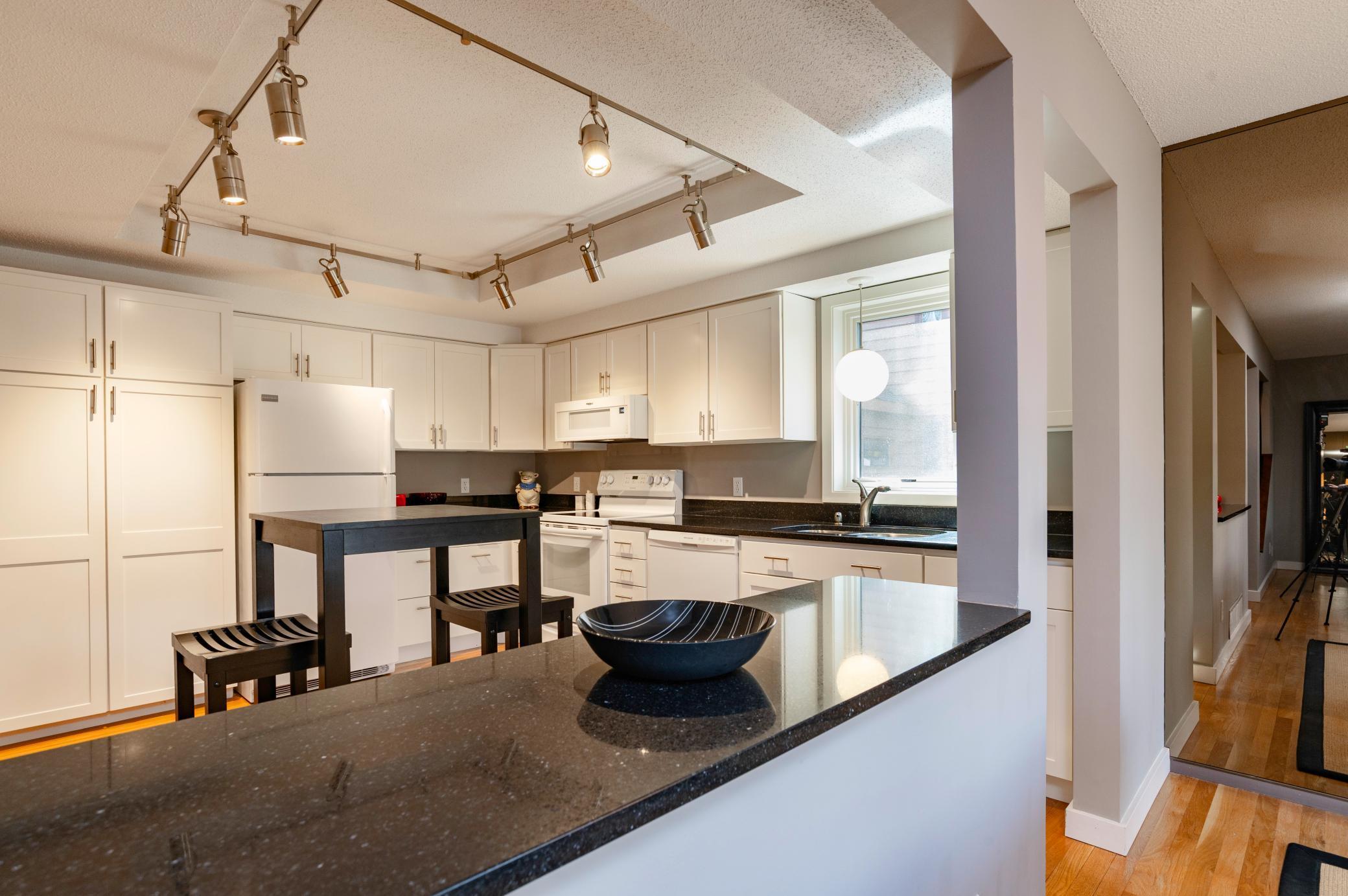 High end designer track lighting provides excellent lighting for all angles of the kitchen.