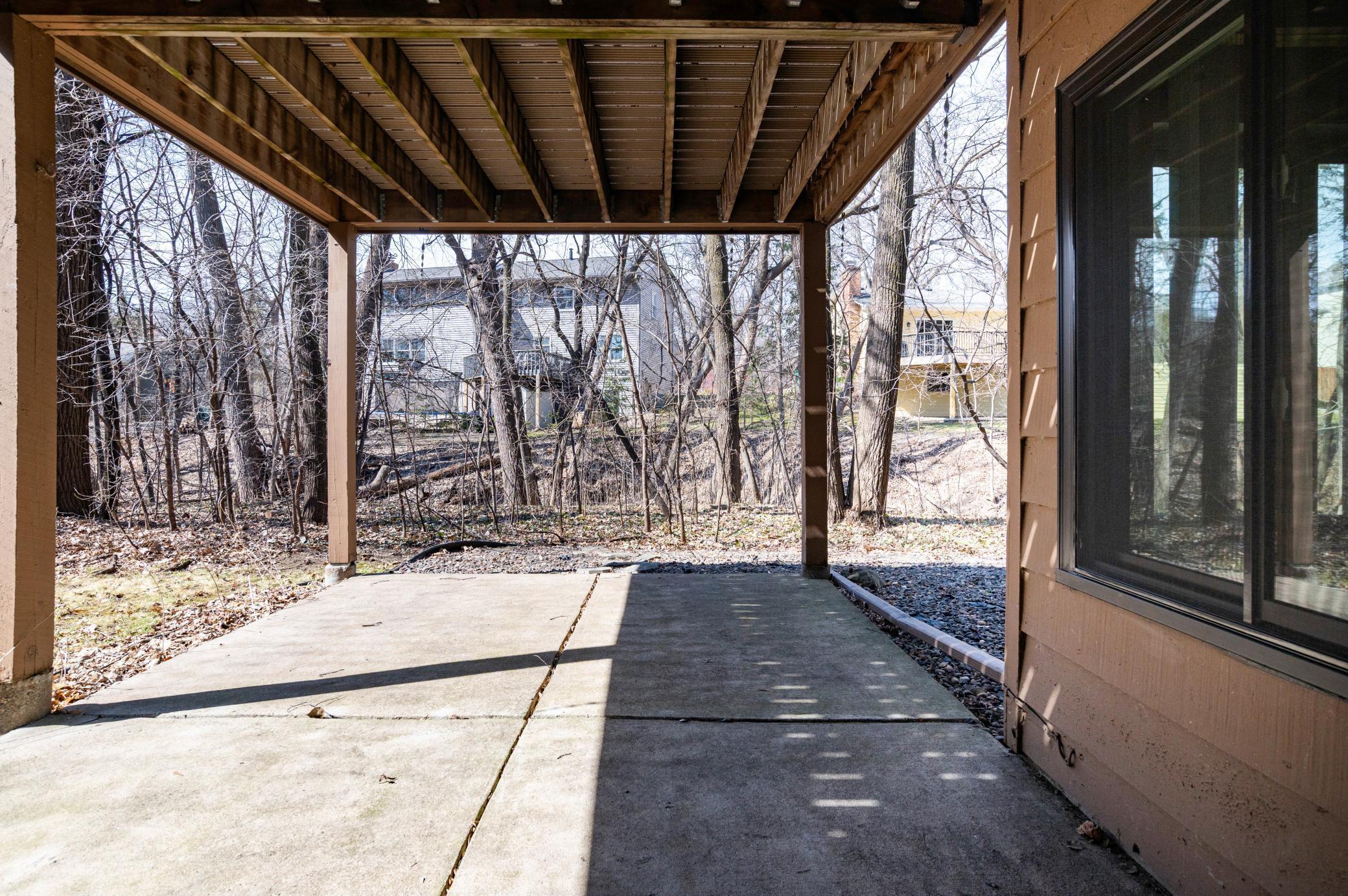 Lower level 16 x 11 concrete patio with access to backyard and view of creek.