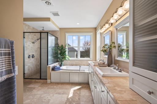 Sophisticated private bath featuring a dual vanity & the ultimate luxury of a spacious walk-in closet located inside the suite for a seamless and effortless organization