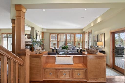 Step into a warm and inviting entry featuring detailed woodwork, built-in bench seating, and an open layout that leads into the main living areas