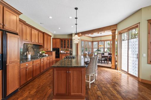 Elegant pendant lighting enhance the functional yet refined design, while expansive windows fill the home with natural light, complemented by timeless hardwood flooring and thoughtful