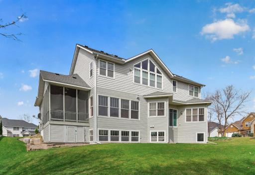 The rear of the home features a welcoming green space that adds a touch of outdoor charm, complemented by convenient storage access that enhances everyday practicality and ease