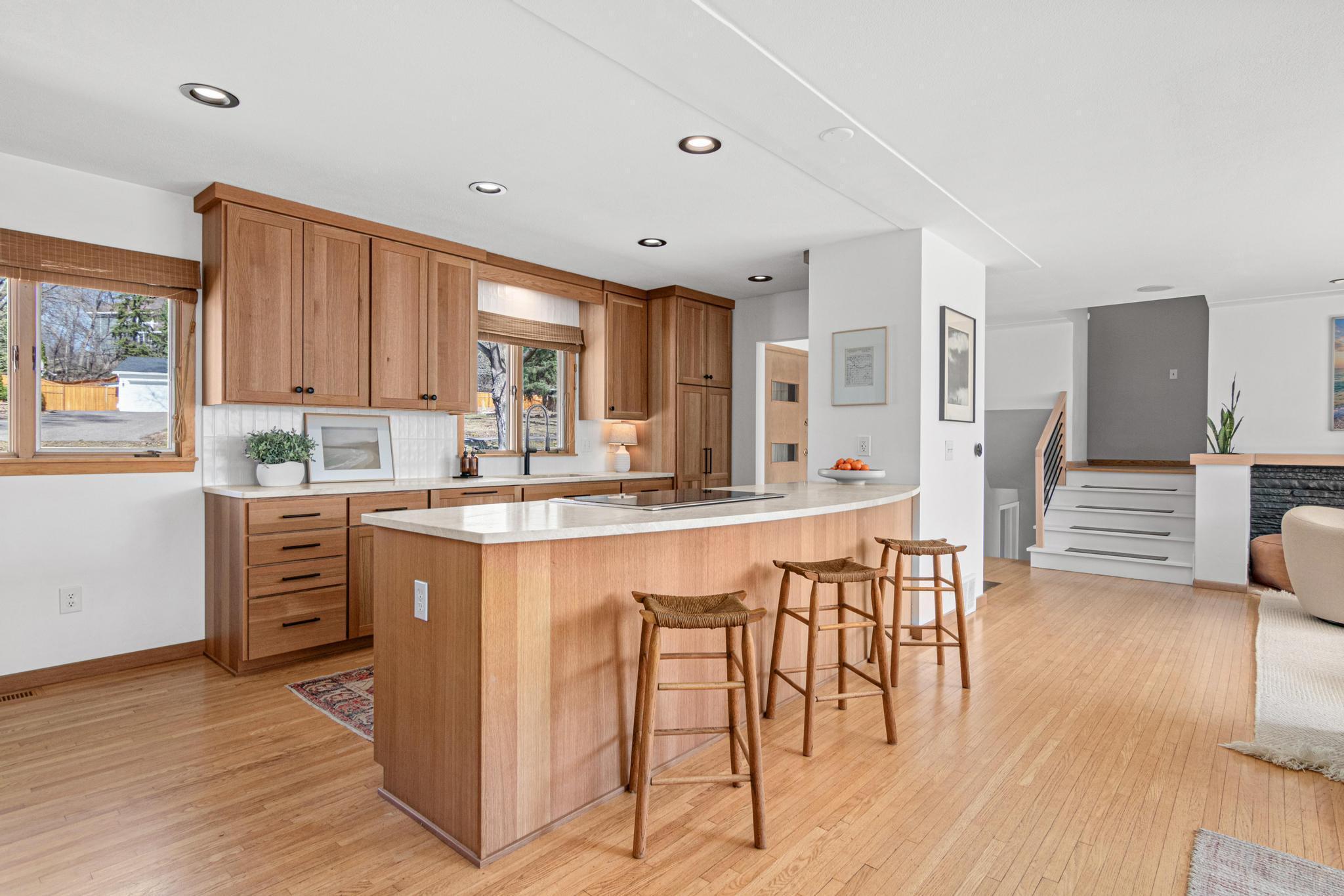 Wide-open to the dining and living spaces, the kitchen functions as the true social hub of the main level. The island seats four comfortably and the flow between cooking, dining, and relaxing is completely seamless.
