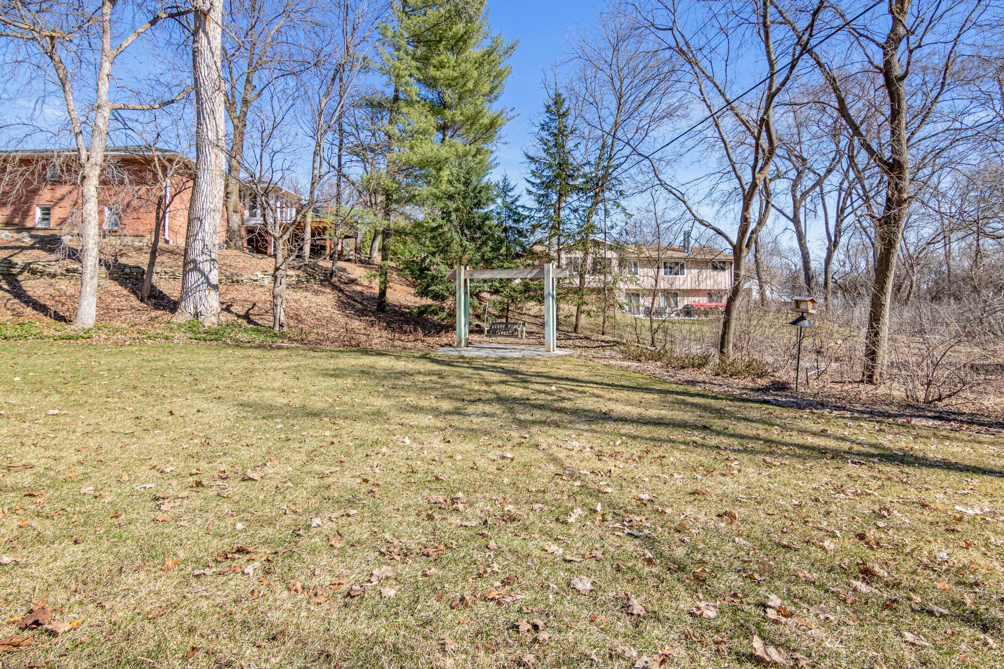 The private, beautifully landscaped yard offers generous lawn space for games, gatherings, and four-legged family members, all wrapped in a setting that feels like your own retreat.
