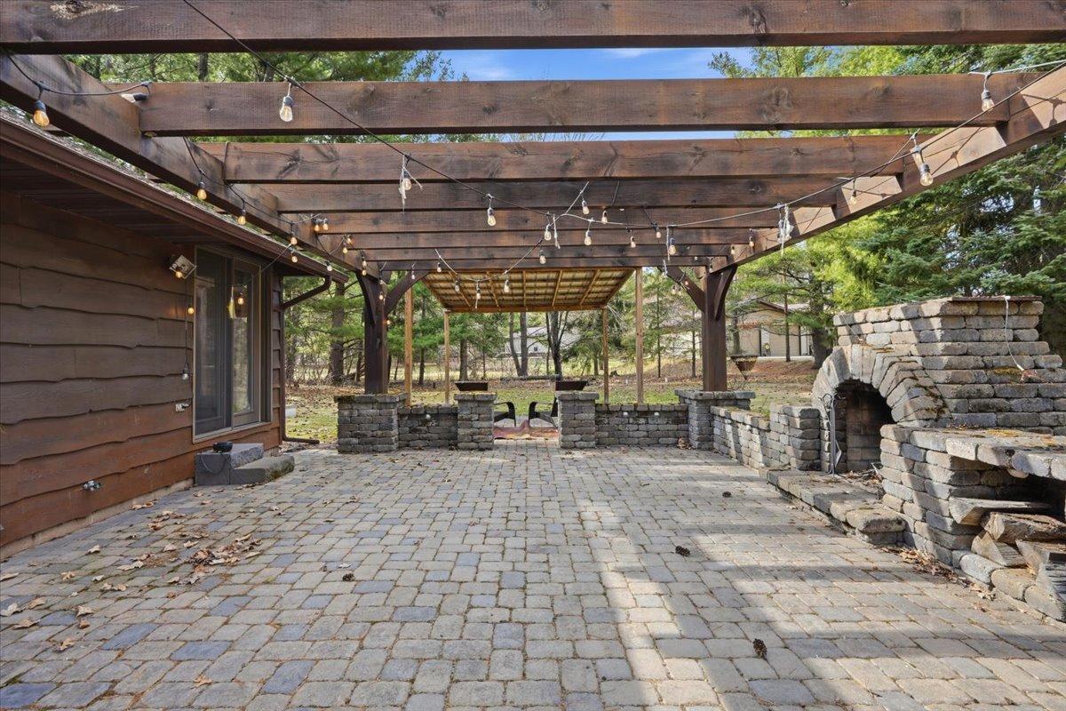 Back patio with stone fireplace ready for summer evenings!
