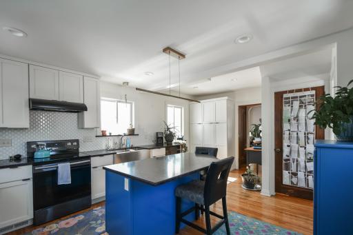 From this view the dining room is to the right, the wooden door goes down to the basement, there is a 1/2 bath at the bottom of the stairs and then it enters into the living room/sunroom area. Again beautiful hardwood throughout!