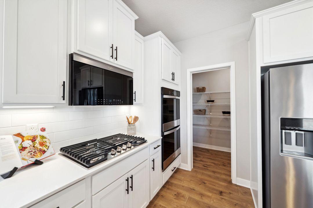 The center of the home, the kitchen! Large island, quartz countertops, subway tile backsplash, gas cooktop, double ovens, and huge walk-in pantry!