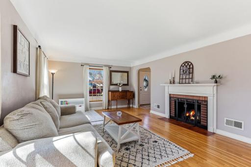 Charming wood-burning fireplace adds warmth and character, creating a welcoming atmosphere in the living room
