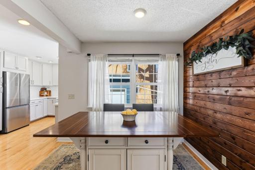 Engineered wood flooring flows throughout the kitchen, informal dining area, and family room, adding warmth, durability, and a cohesive look.