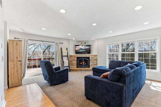 Bright and open, this family room features large windows that flood the space with natural light and a slider to the deck for seamless indoor-outdoor living. Perfect for entertaining