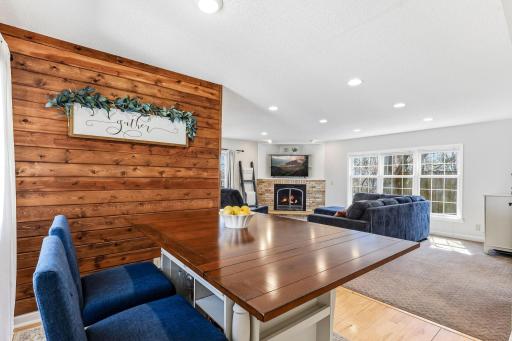 Warm wood accent wall adds texture and character to the informal dining space, creating a cozy, inviting setting.