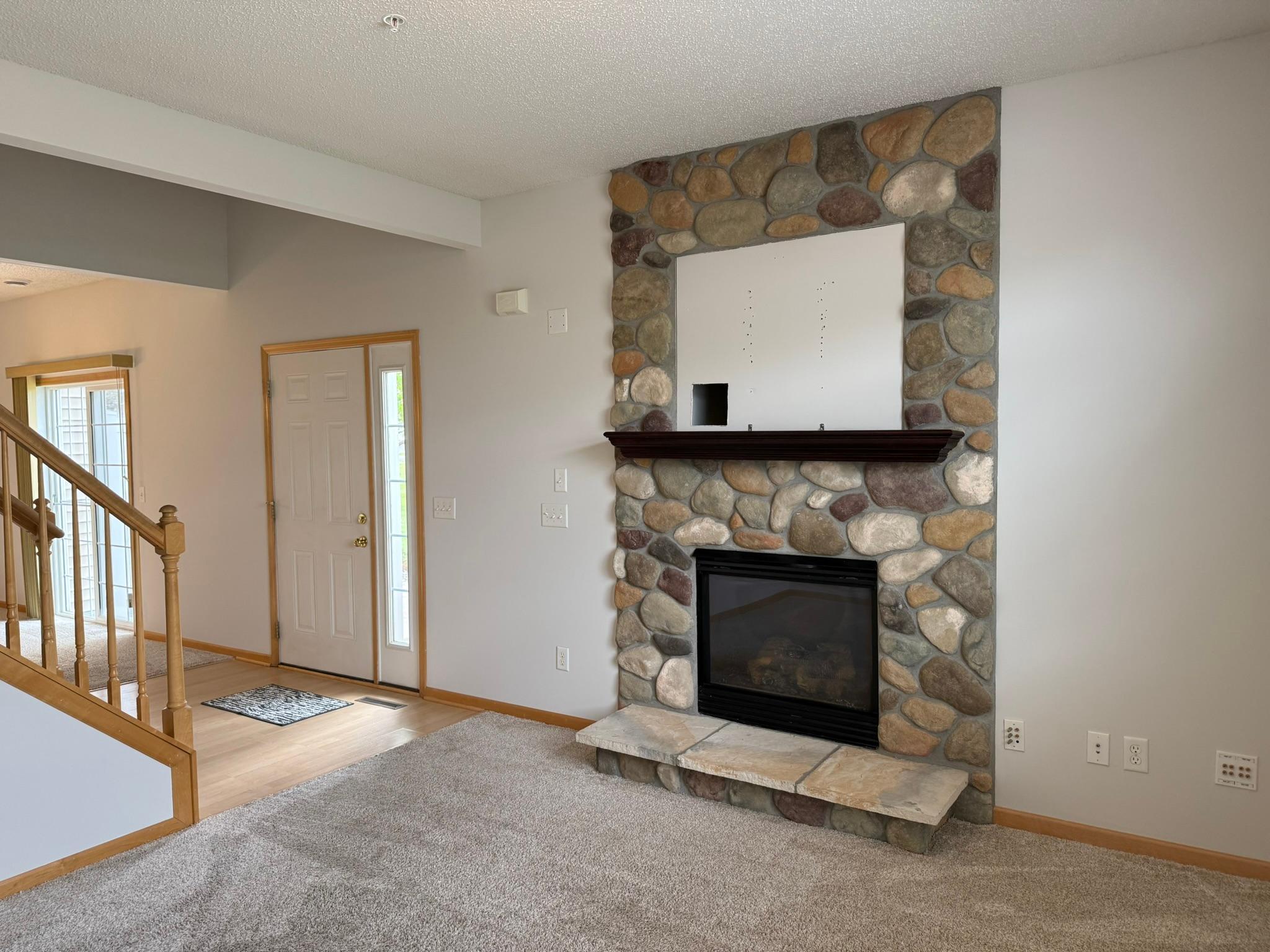 Gas burning fireplace surrounded by stone and perfect spot to mount your TV in living room