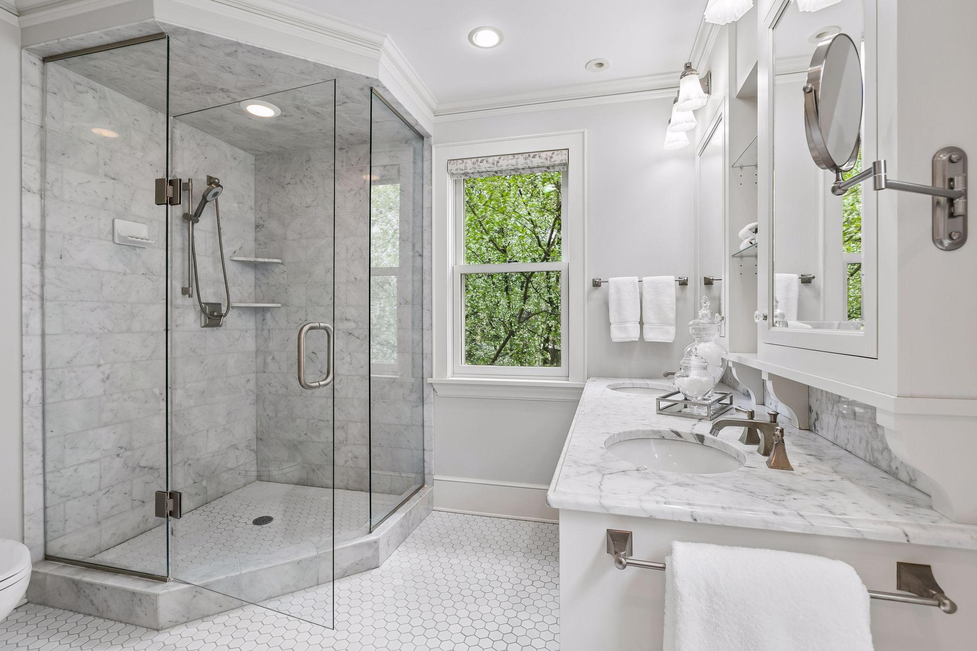 Marble countertops, a double vanity and a tile walk-in shower
