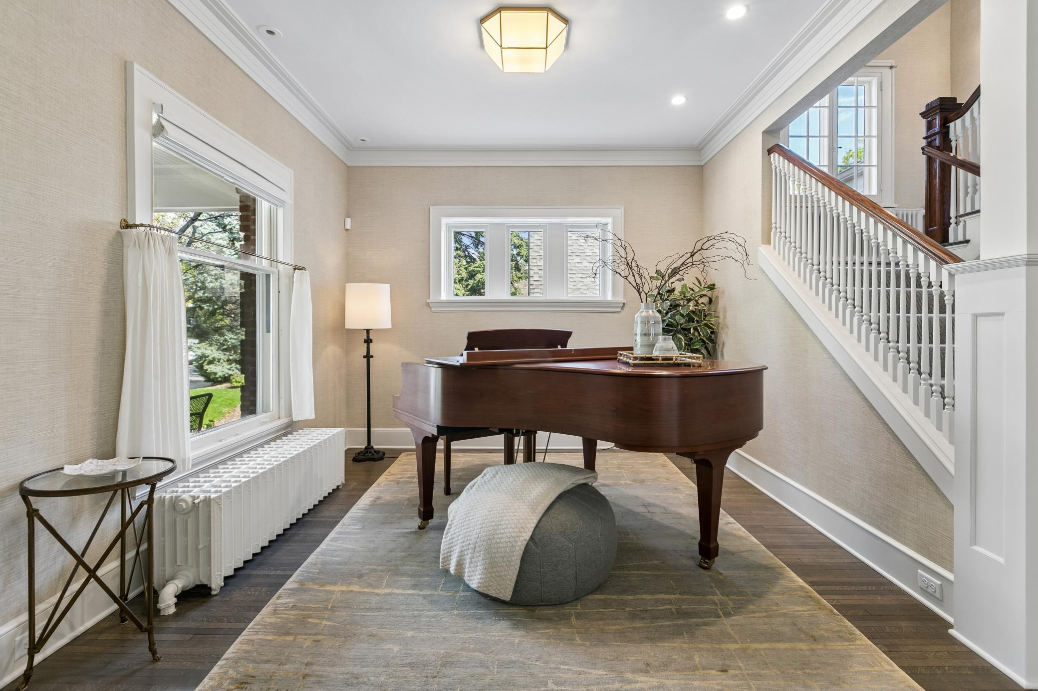 The front room is a perfect spot to showcase your piano. The stairway wall was removed to bring in light and create a more open feel. Craftsman created duplicate balusters to match the originals.