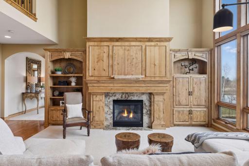 Gorgeous rich hickory paneled fireplace with a sophisticated marble surround and built - ins
