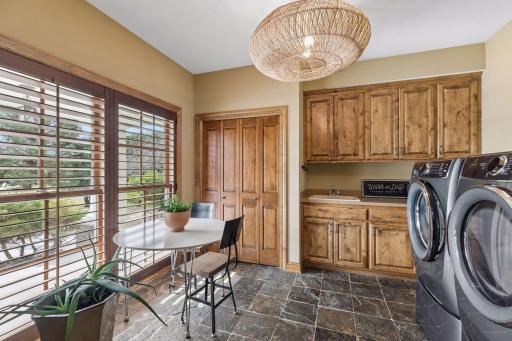 Every family will love this massive dedicated laundry space with an extraordinary amount of storage and stone flooring makes it ideal for daily use. Perfect for a pet clean up area.
