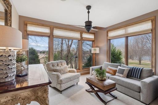 A main floor den surrounded by floor-to-ceiling windows. a qioet sanctuary for reading and relaxing.