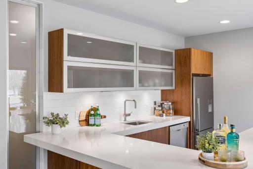 Resort style bar kitchen overlooking the sparkling pool and private backyard oasis.