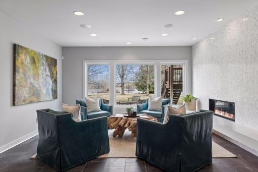 This cozy sitting area overlooks stunning views of the backyard and a floor to ceiling art-like display featuring the fireplace will impress.