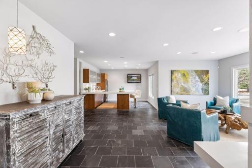 The expansive natural stone tile floor brings warmth and texture to this gorgeous entertainment space.