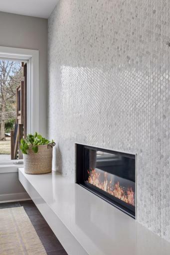 Stunning mosaic-tiled fireplace wall is dramatic and impressive.