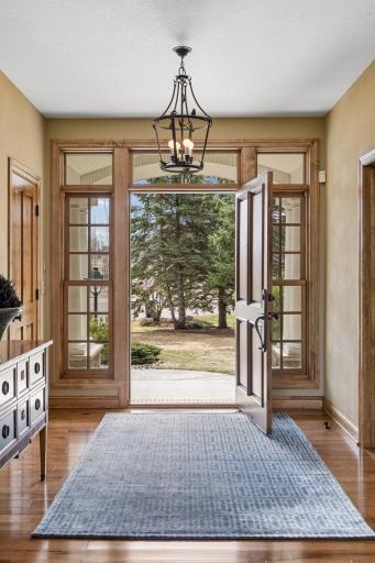 Stepping through the front door, you are welcomed by a dramatic two-story foyer with rich hickory flooring.