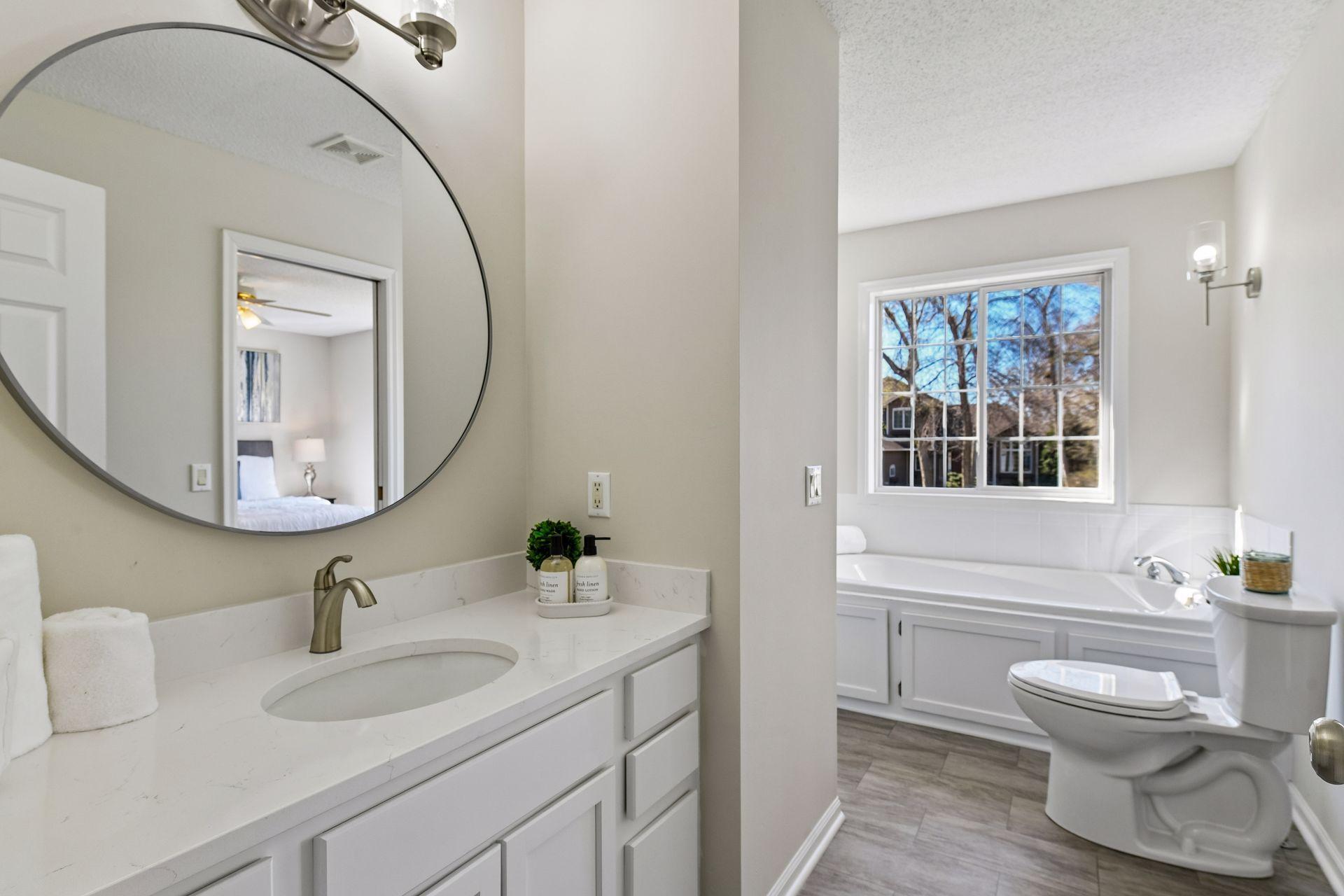 Full main upper bath refresh! New flooring, light fixtures, Quartz vanity, mirror, faucet, toilet and more.