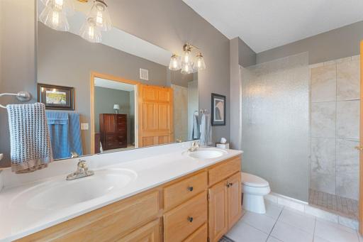 Separate tiled shower with built-in seating and grab bars