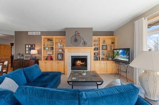 Living room with custom built-in cabinetry and glass fireplace