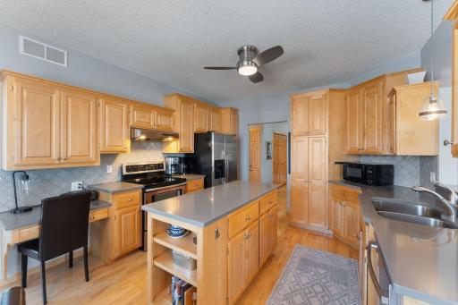Kitchen with maple cabinetry, stainless steel appliances, and quartz countertops