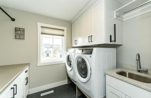Laundry on upper complete with sink, storage and folding table