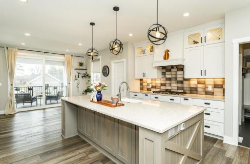 Large center island and gas range with hood vent