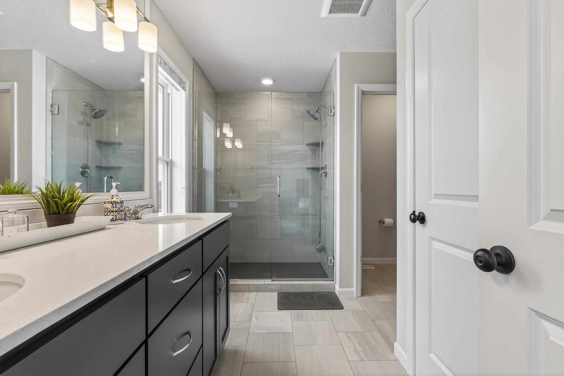 Primary bath with dual sinks, walk-in shower, walk-in closet and separate