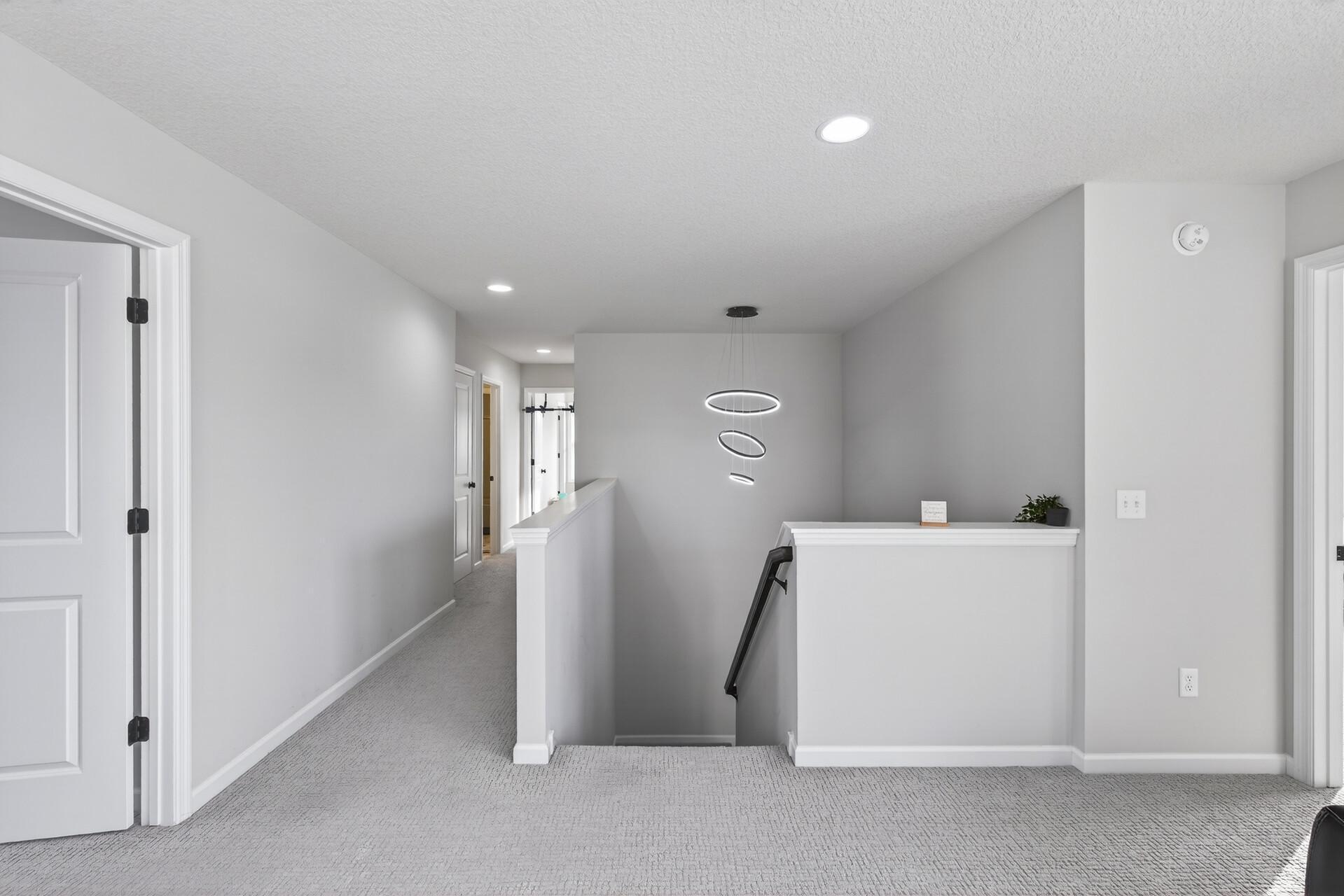 Large upstairs landing with modern chandelier over the staircase